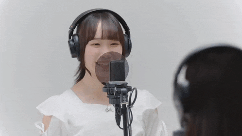 a woman wearing headphones sings into a microphone