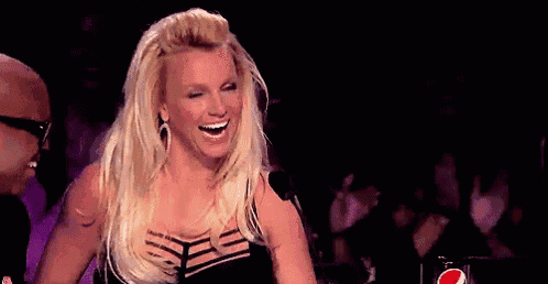 a woman in a black dress is holding her hair in front of a microphone .