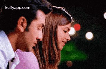 a man and a woman are hugging each other and looking into each other 's eyes .