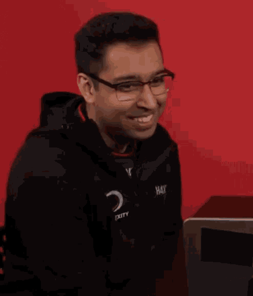 a man wearing glasses and a jacket that says gexity on it