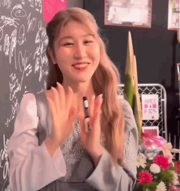 a woman applauds in front of a blackboard that says the best capacity