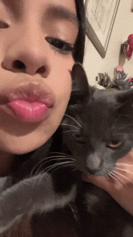 a woman with pink lips is holding a cat
