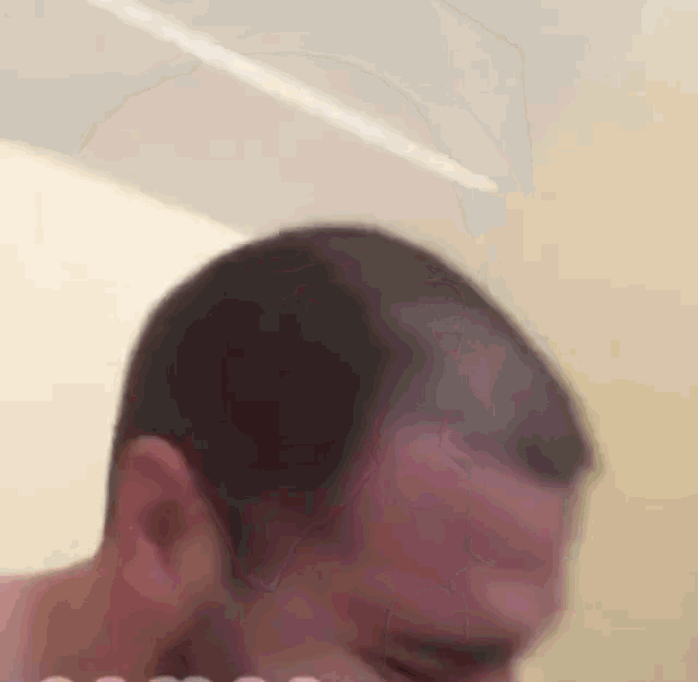 a man 's head is shown in a blurry photo with a white background .