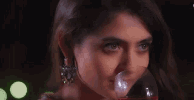 a close up of a woman drinking from a glass