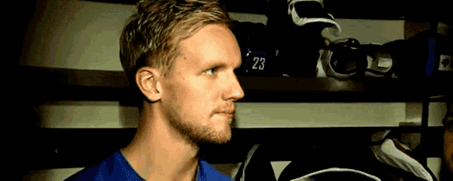 a man in a blue shirt has the number 23 on his shirt