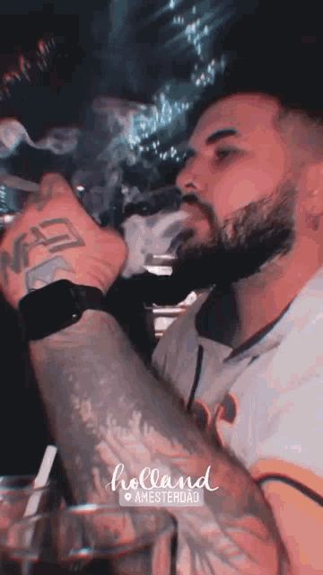 a man with a beard is smoking a cigarette with the word holland on the bottom right