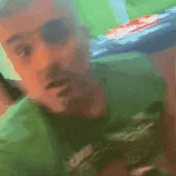 a man in a green shirt is holding a pepsi can