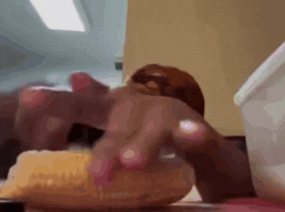 a close up of a person eating a donut with their hand