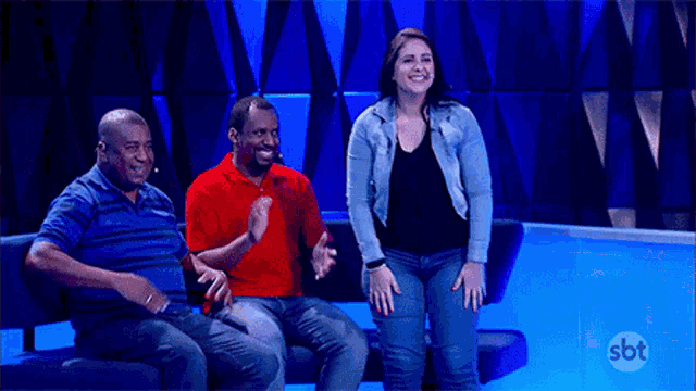 a group of people are sitting on a couch with sbt written on the bottom
