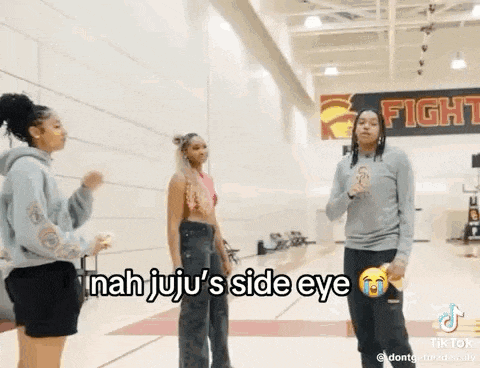 a group of girls are standing next to each other in a gym .