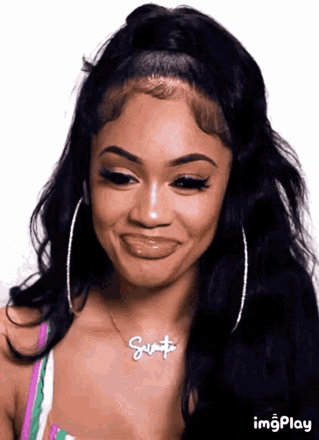 a woman wearing hoop earrings and a necklace with the name santa on it .