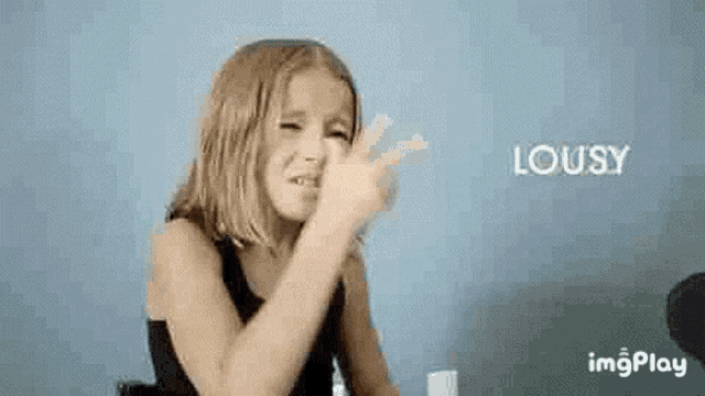 a little girl is making a funny face and making a funny face with her hands .
