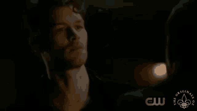 two men are standing next to each other in a dark room holding swords .