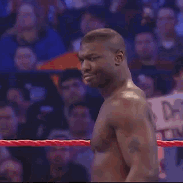 a man is standing in a boxing ring with a crowd watching