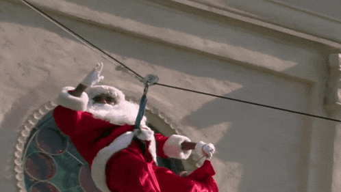 a man in a santa suit is hanging from a power line