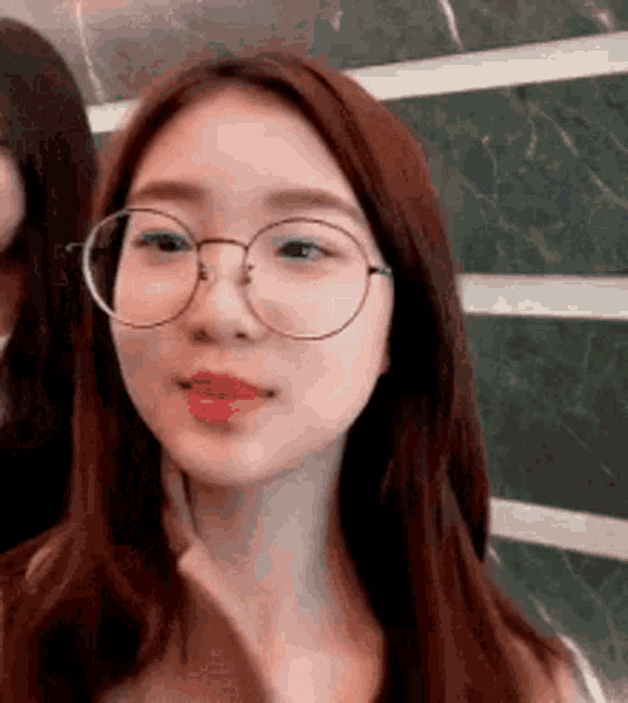 a close up of a woman wearing glasses and lipstick .