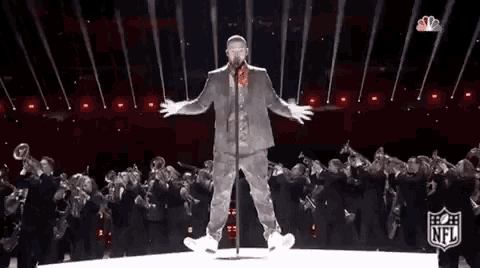 a man is standing on a stage holding a microphone .