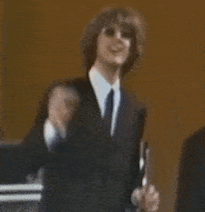 a man in a suit and tie is dancing on a stage .