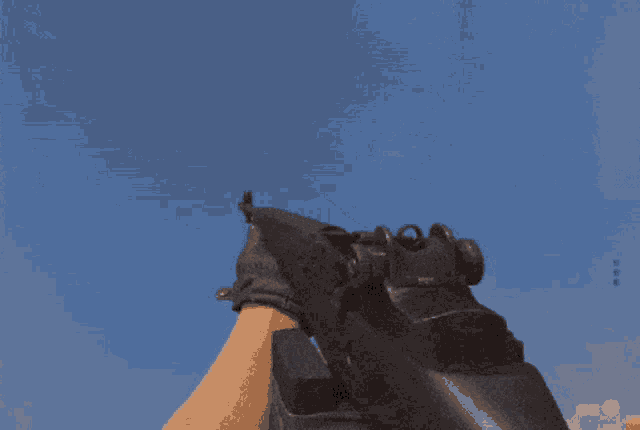 a person wearing black gloves is holding a rifle