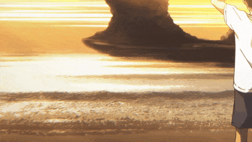 a person standing on a beach with their arms up in the air