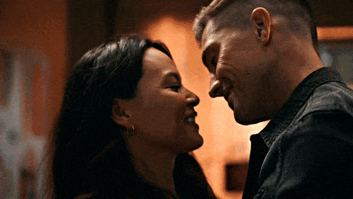 a man and a woman are looking into each other 's eyes and smiling