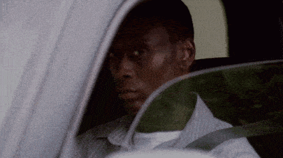 a man in a striped shirt is looking out of a car window