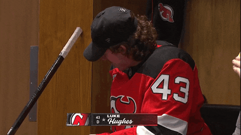 a hockey player with the number 43 on his jersey drinking water