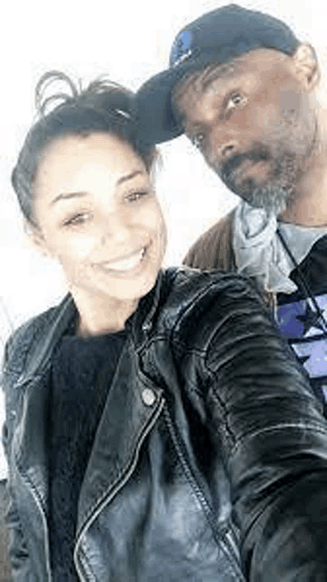 a man and a woman are posing for a selfie together .