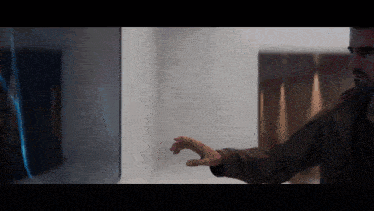 a man in a brown jacket is touching a screen with his finger