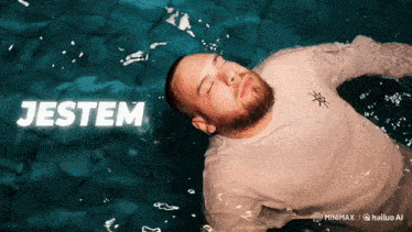 a man in a white shirt is floating in the water with the word jestem above him