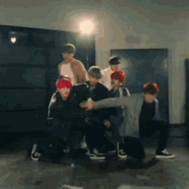 a group of young men are kneeling down on the floor in a room .