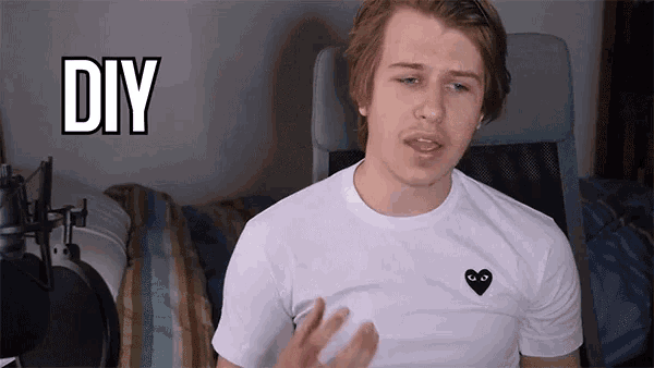 a man wearing a white shirt with a black heart and the word diy behind him