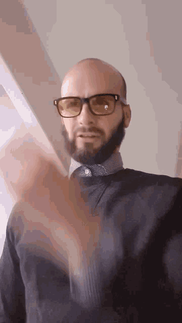 a man with a beard wearing glasses and a black sweater