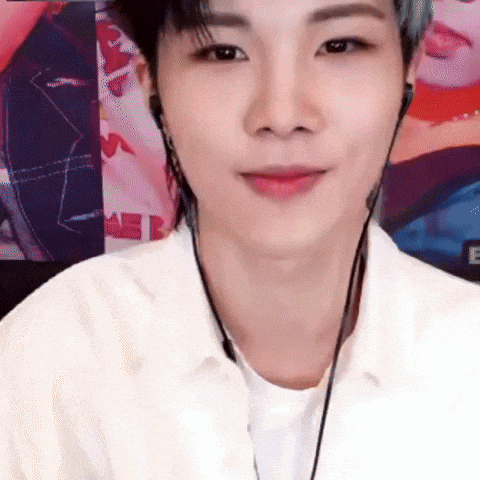 a young man wearing headphones and a white shirt is looking at the camera .
