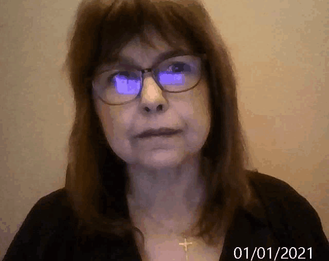 a woman wearing glasses and a cross necklace has the date 01/01/2021 on the bottom