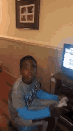 a boy wearing a shirt that says ' washington ' on it is sitting in front of a computer