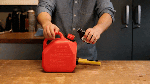 a man is pouring gas into a red container that says danger