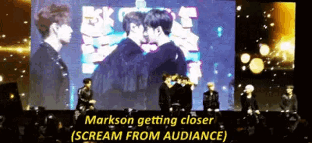 a group of people are standing in front of a large screen and screaming .