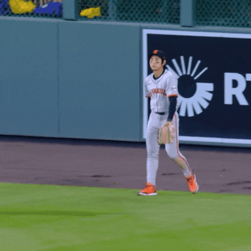 a baseball player wearing a jersey that says giants is running on the field