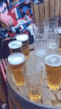 a bunch of beer glasses are on a wooden table .
