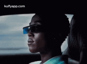 a man wearing sunglasses is sitting in a car .