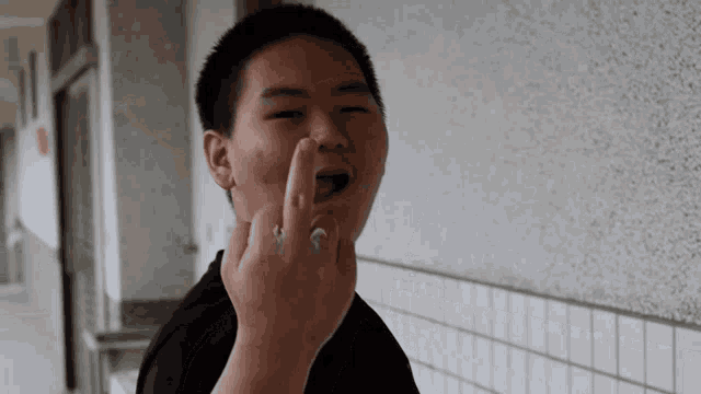 a young man is making a funny face and giving the middle finger
