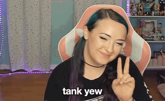 a woman with purple hair is giving a peace sign and the words tank yaw are visible