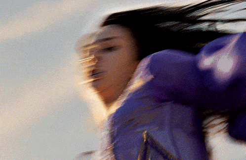 a blurry picture of a woman wearing a purple shirt