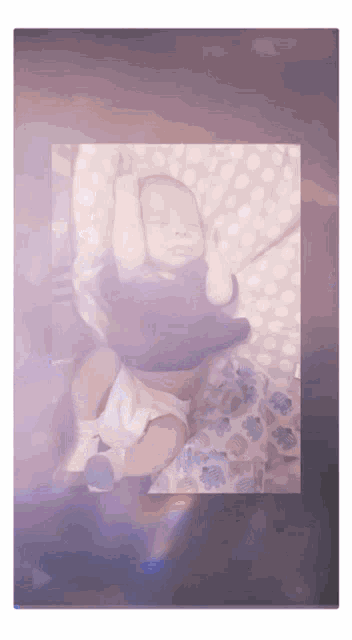 a baby in a diaper is laying on a polka dot pillow