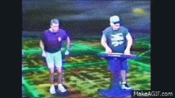 two men are standing in a field and one of them has a shirt that says ' chinese ' on it