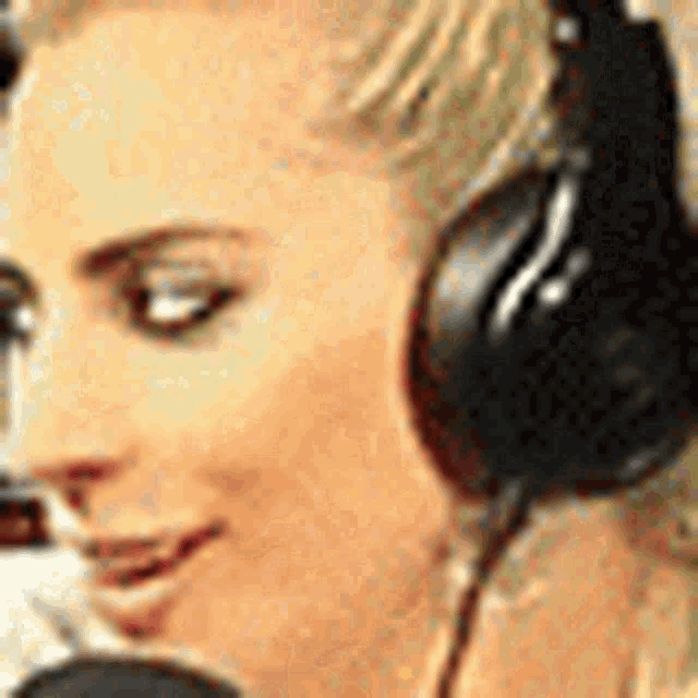 a woman wearing headphones and a microphone is smiling .