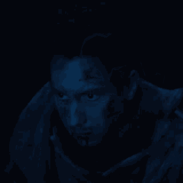 a man with blood coming out of his mouth is in the dark