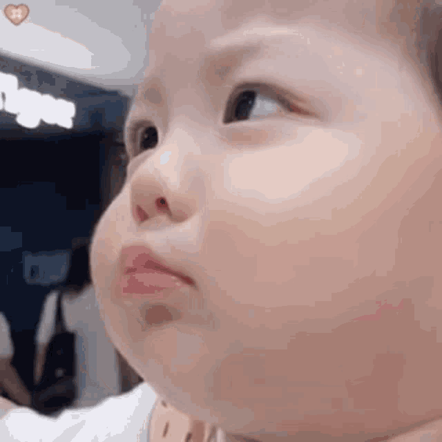 a close up of a baby 's face making a funny face with his mouth open .