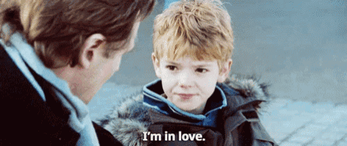a young boy is talking to a man and saying `` i 'm in love . ''